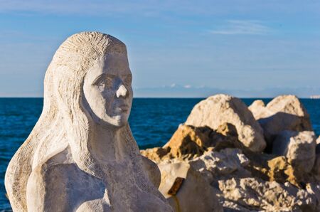 Mermaid sculpture carved out of the stone rocks at Piran harbor, Istria, Sloveniaの写真素材