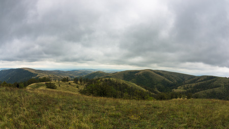 Dark clouds of summer storm over the prairie path through hillsides with dry vegetation, central Serbiaの写真素材