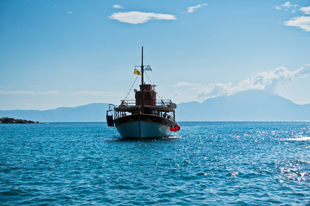 Ship is sailing to small Sarti harbor, mount Athos in background, Sithonia, Greeceの写真素材