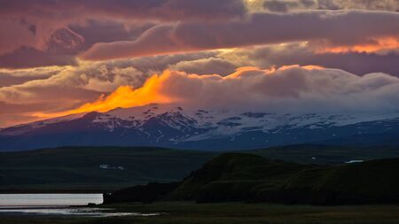 Sunset fire and ice of Vatnajokull glacier, a view from black beach near Vik, south Icelandの写真素材