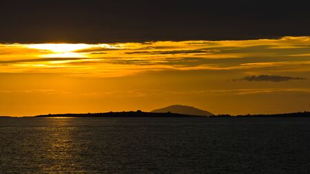 Sunset at sea, with small greek islands in background, Sithonia, Greeceの写真素材