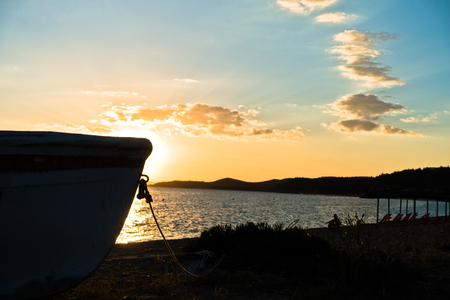 Silhouette of a boat on a beach at sunset in Sithonia, Greeceの写真素材