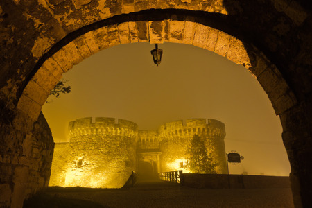 Bridge and towers of Kalemegdan fortress covered with fog at night, Belgrade, Serbiaの写真素材