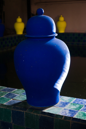 Blue and yellow pots at the edge of tiled fish pond in Majorelle garden Marrakech, Morocco, Africaの写真素材