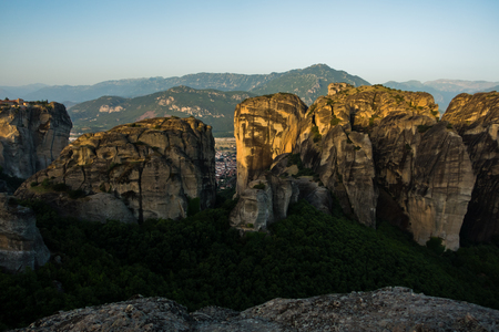 Huge rocks with christian orthodox monasteries at sunrise with Meteora valley in background near Kalambaka, Thessaly, Greeceの写真素材