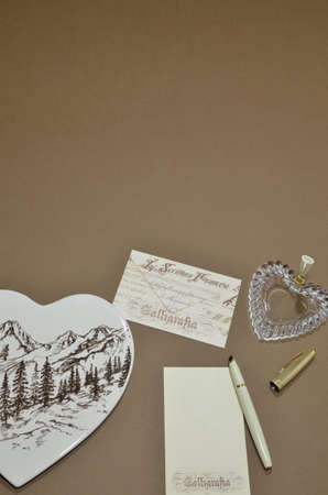 Set of letters, pen and penholder heart shaped on a brown background.の写真素材