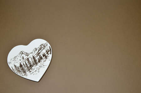 Porcelain heart with mountain and trees print on brown backgroundの写真素材
