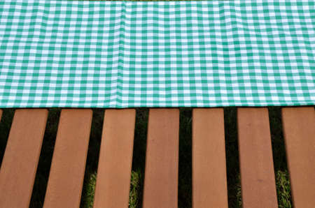 Green and white tablecloth and wooden surface set outdoorの写真素材