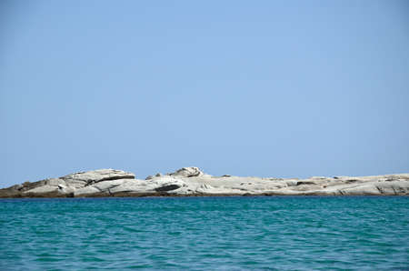 Rocky cay on a horizon between sea and sky