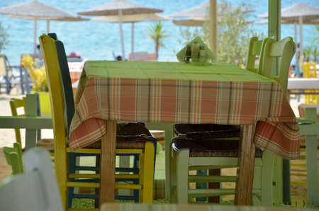 Greek restaurant set on a beach with parasols in background