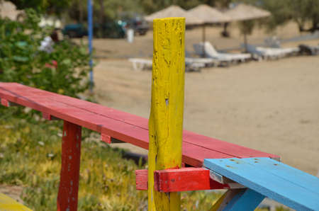 Part of colorful beach bar wooden construction with beach parasols and sunbeds in backgroundの写真素材