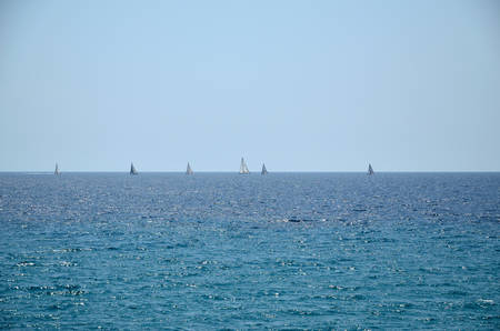 Sailing boats in horizon of turquoise sea and blue skyの写真素材