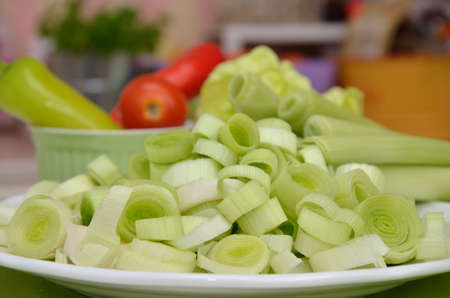 Leek rings on a plate with other vegetables in background