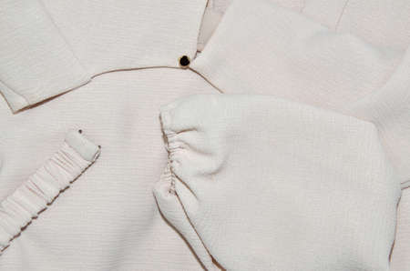 Dress made of fine pale pink woolen fabric with focus on its sleeve, collar and belt