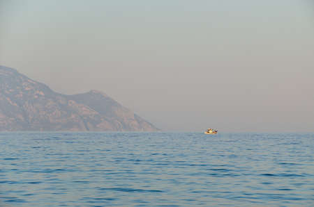 Boat on the Aegean sea and part of the land in Greeceの写真素材