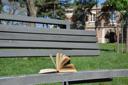 Open book on bench in the school yard on a windy dayの写真素材