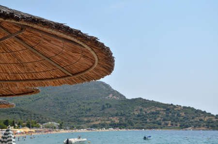 Straw parasol on a beach in summer timeの写真素材