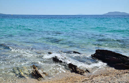 Rocks on beach and turquoise sea water in summerの写真素材