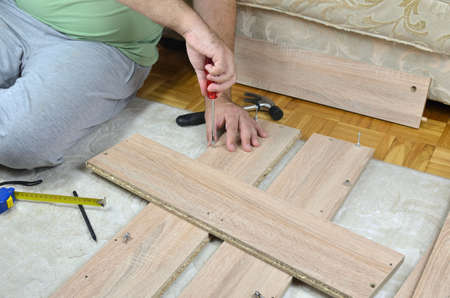 Man assembling a drawer of a new cabinet with DIY toolsの写真素材