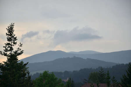 Grey sky with clouds over mountain hills bringing stormy weather in late afternoonの写真素材