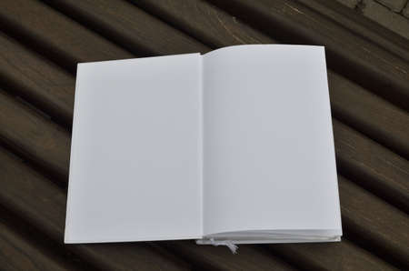 Opened book on a wooden surface with space for copy text as a backgroundの写真素材