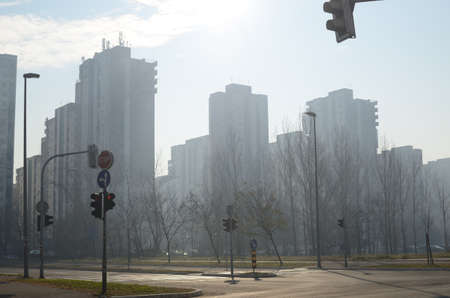 Modern residential buildings and crossroad on foggy morning in fall