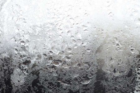 Icy window surface with frostwork as a backgroundの写真素材