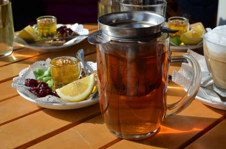 Served glass cup of tea with a set of dry fruits, lemon and honeyの写真素材