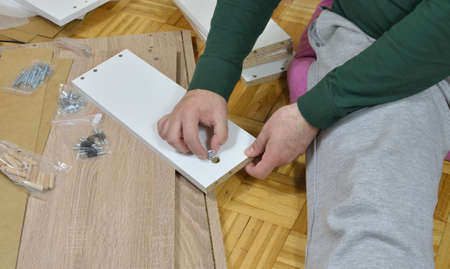 Man assembling elements of a new cabinet drawer