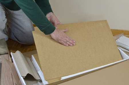 Man taking out of a box elements of a new piece of furnitureの写真素材