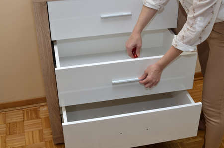 Woman's hands attaching a handle of a drawerの写真素材
