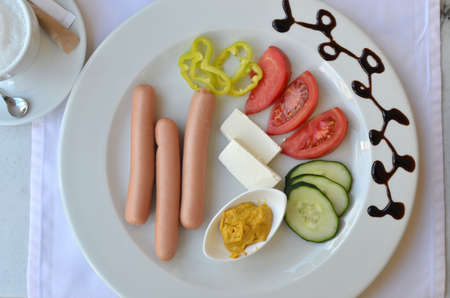 Plate with served breakfast - hot dogs and fresh vegetablesの写真素材