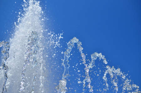 Top of a foamy fountain water against clear blue skyの写真素材