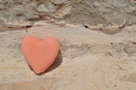 Pink color bath salt figure in a shape of heart on stone surfaceの写真素材