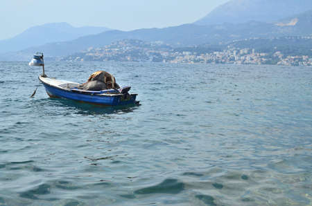 Small fish boat with hidden fishing gear on a calm sea surface