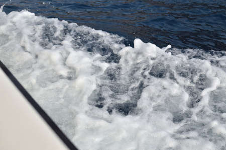 White foam of a blue sea wave in summerの写真素材