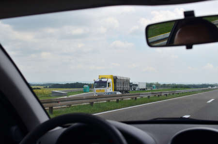 Driving on a highway with cars and trucks in opposite direction