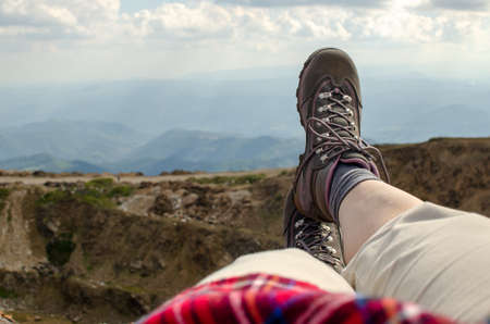 Legs in tracking shoes resting on a mountain fieldの写真素材