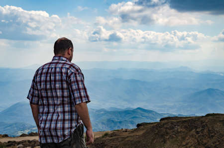Man dressed for hiking observing a landscape from top of Kopaonik mountain, Serbia