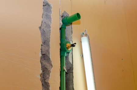 New plastic water pipes installed in a chased bathroom wall and a neon lamp during renovation works