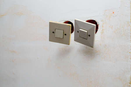 Old switches detached from a wall during renovation works in an apartment
