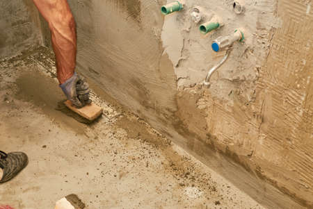 Applying layer of isolation material with a brush on a floorの写真素材