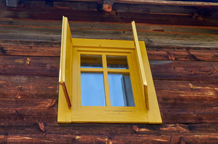 Window of a traditional wooden cottage with open jalousiesの写真素材