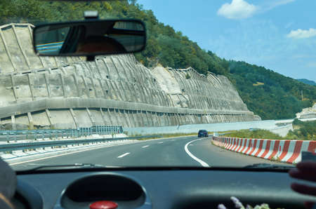 Driving a car on a asphalt highway through a gorge