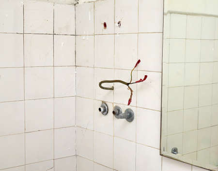 Bathroom with old white tiles and electric wiresの写真素材