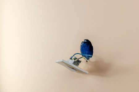 Detached an old light switch and an electric wires hanging from a wall