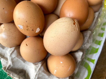 pile of eggs some broken in a box some visible
