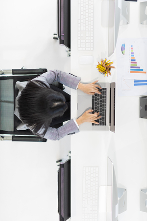 Long black hair wamon typing on computer keyboard of notebook computer, taken from top viewの写真素材