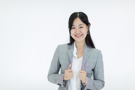 Beautiful Asian girl with long hair looks good smil wearing a suit. Standing on white background, studio shot.の写真素材