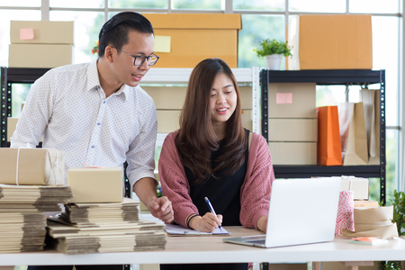 Young Asian couple business  working in simple house office look like doing startup business. Concept for online marketing, SME and home base workplace.の写真素材